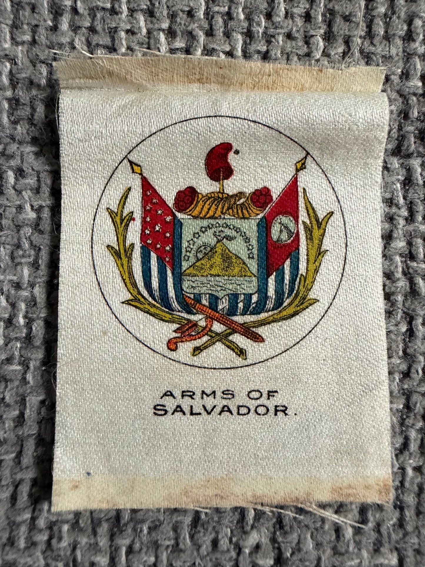 Beautifully detailed silk showing the Arms of Salvador — early spelling variant of El Salvador. Richly coloured coat of arms with volcano, flags & laurel wreath. Issued by Godfrey Phillips / BDV — scarce Central American issue.
