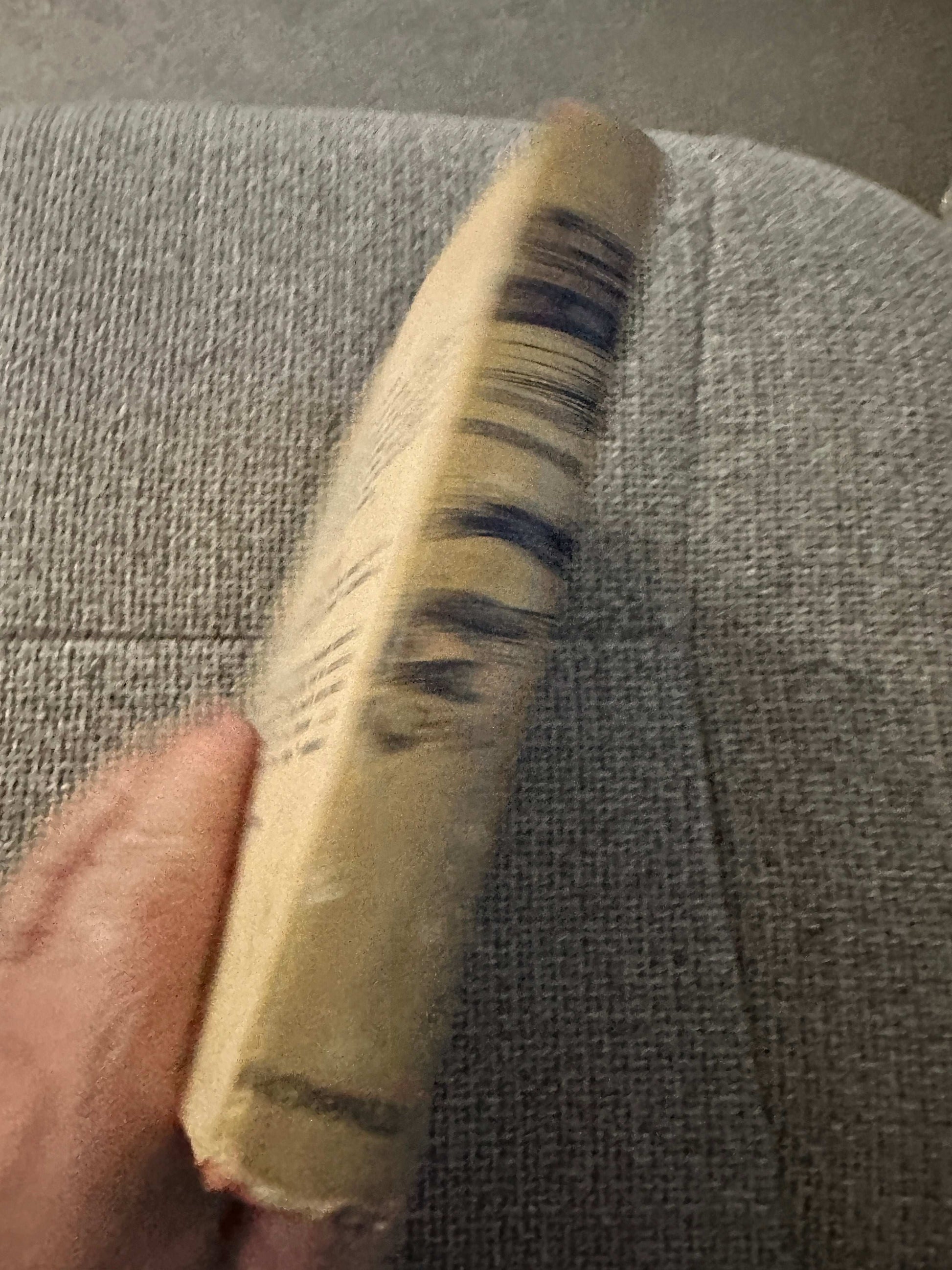 Side view of 1953 A Thousand Witnesses first edition book with worn edges on a textured surface