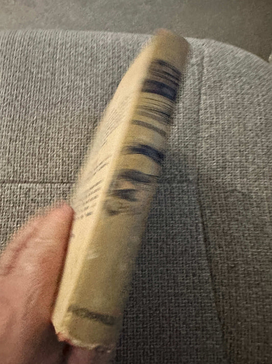 Side view of 1953 A Thousand Witnesses first edition book with worn edges on a textured surface