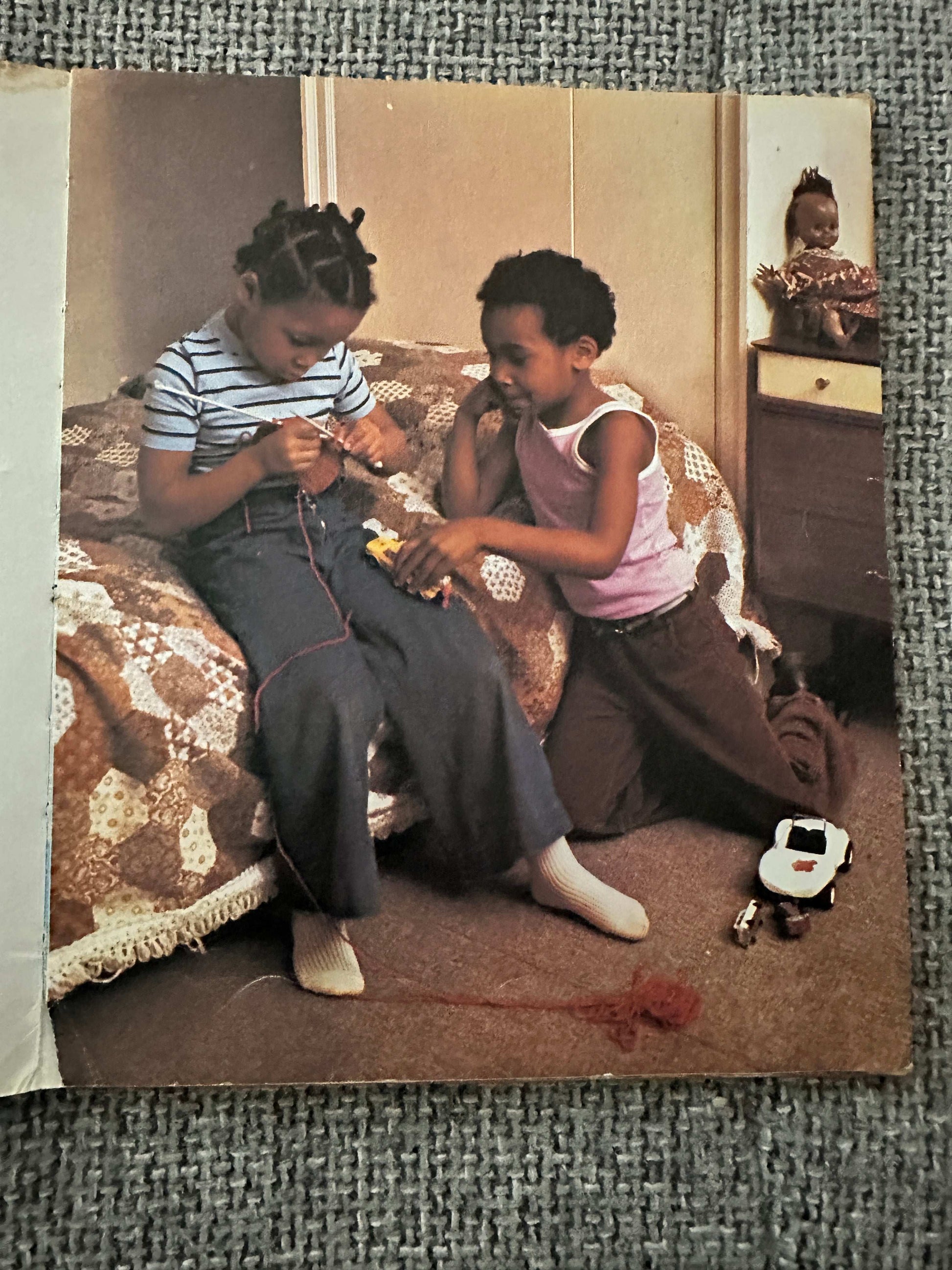 Children reading and playing together with a 1978 Hamish Hamilton collectible book on the bed