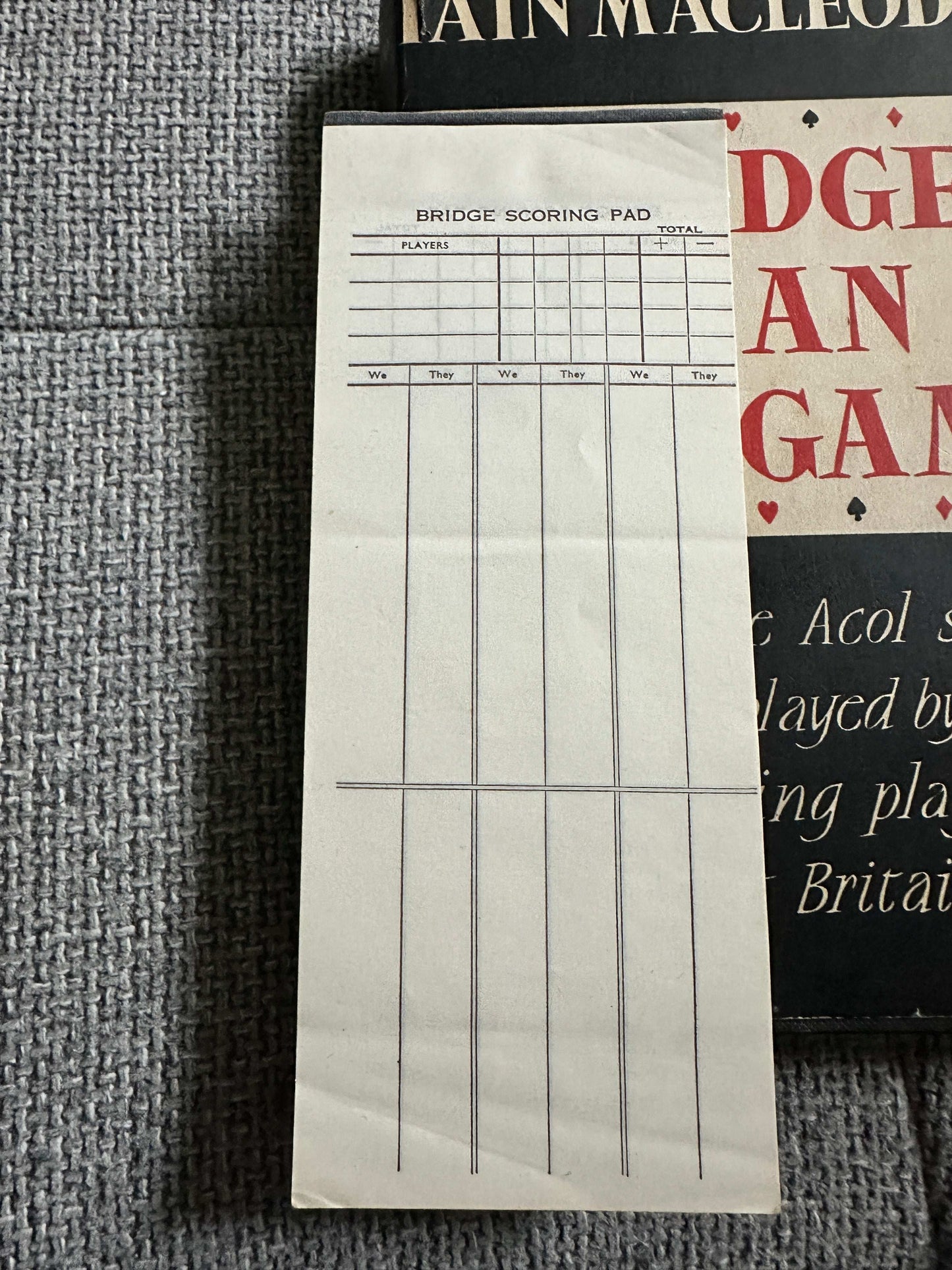 Bridge scoring pad beside the 1959 Bridge Is An Easy Game book for tracking scores during play