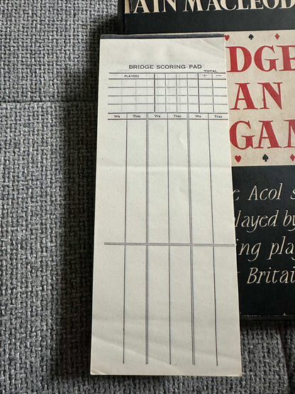 Bridge scoring pad beside the 1959 Bridge Is An Easy Game book for tracking scores during play