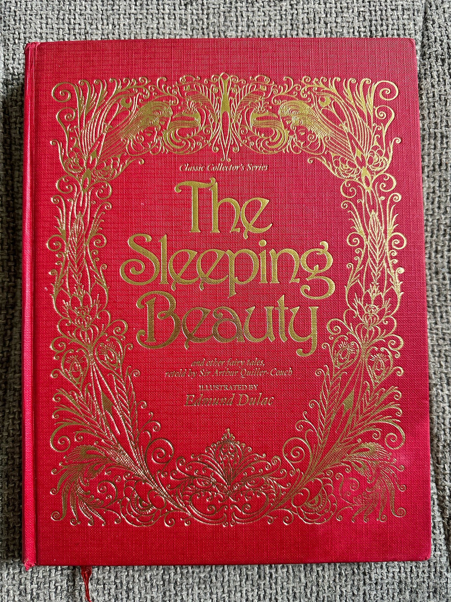 The Sleeping Beauty book featuring Edmund Dulac illustrated fairytales with ornate gold detailing on a red cover