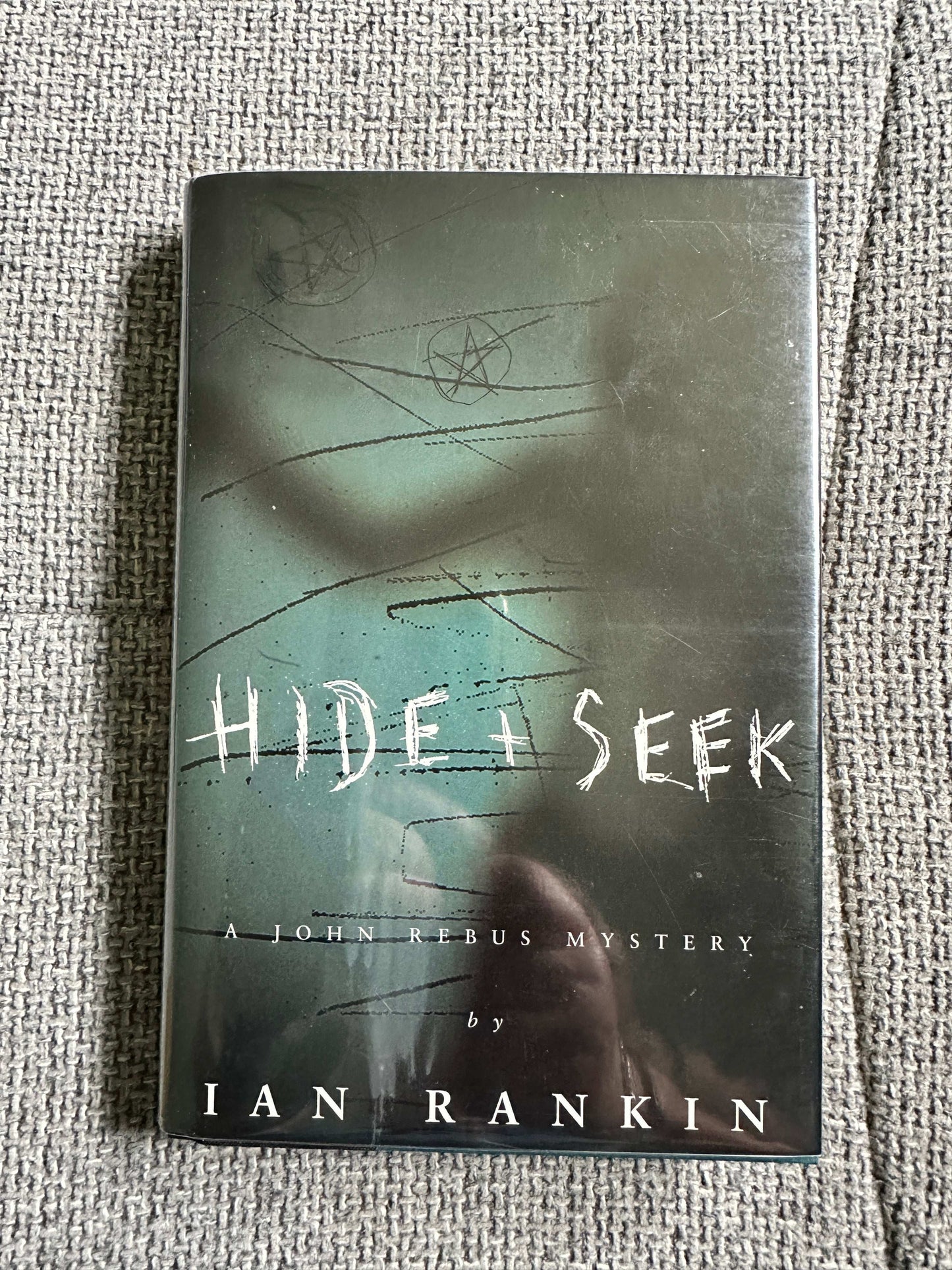Signed Ian Rankin first edition of Hide and Seek, a John Rebus mystery novel with dark cover art.
