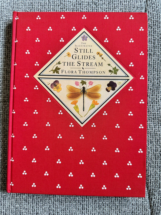 The illustrated edition of Still Glides The Stream Flora Thompson with a red floral cover design