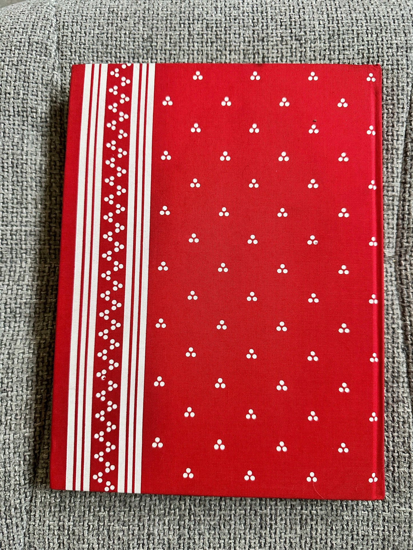 Still Glides The Stream Flora Thompson hardcover book with a vibrant red cover featuring white patterns