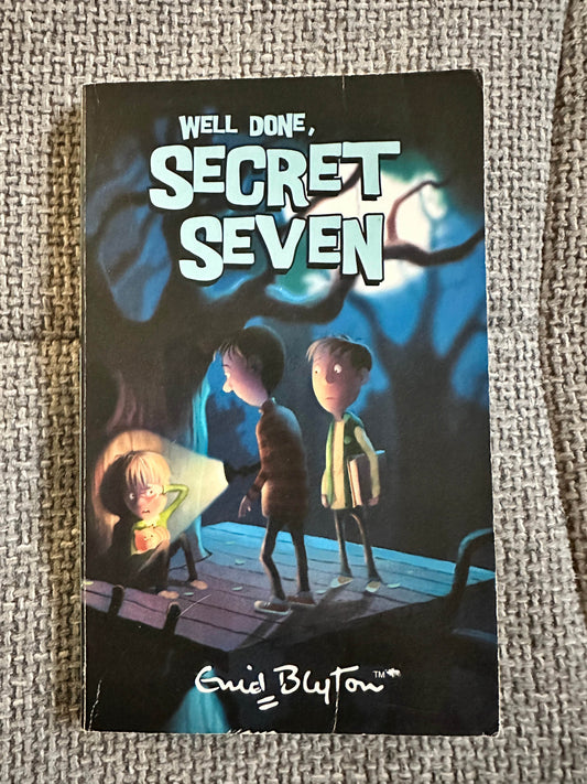 Well Done Secret Seven Enid Blyton book cover featuring children in a spooky forest with a flashlight